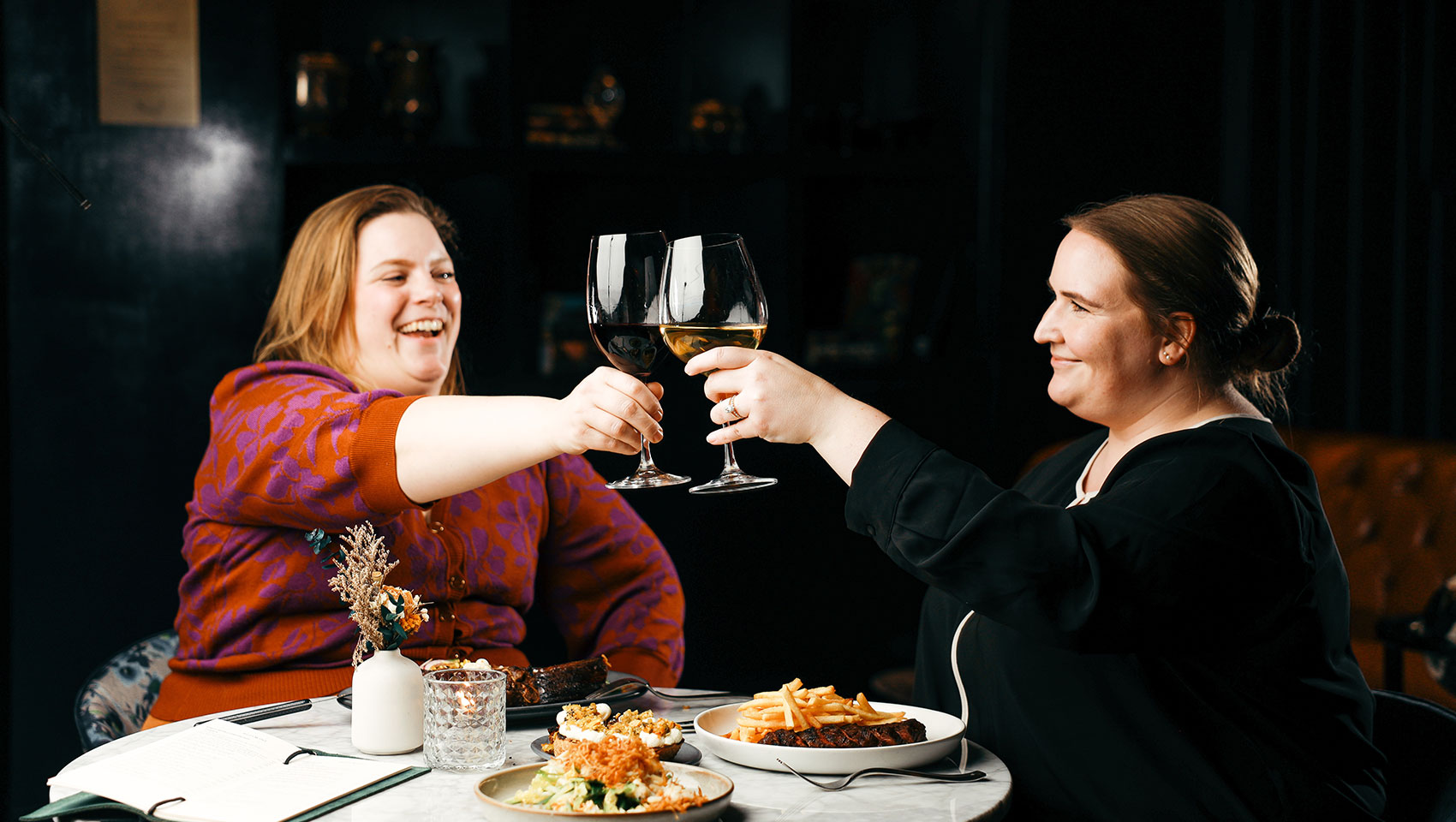 two women cheersing wine in Birch and Bloom