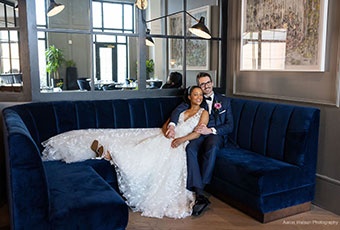 bride and groom sitting on blue velvet couch at kimpton forum hotel