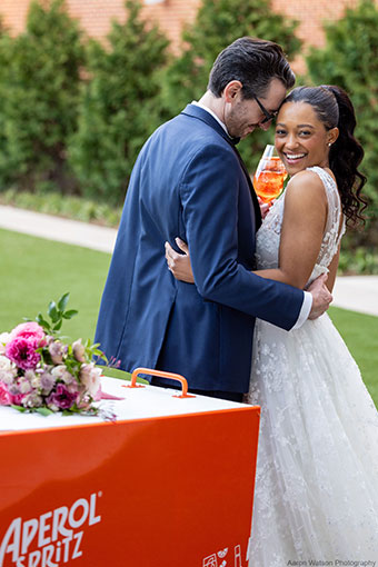 bride and groom with Aperol Spritzes at the Aperol Spritz cart